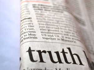 A folded newspaper with part of a headline with the word Truth highlighted