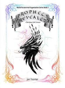 Book cover for Prophecy Revealed. The cover is framed with a blue and purple abstract wisps and it changes to soft red and orange at the bottom of the frame. On top center reads "World Paranormal Organization Series Book 2". Below are Two ribbon scrolls, and on them are written "Prophecy Revealed". Underneath the scrolls is "Clarima Syd Jones". A dragon's head is in the center. At the center bottom of the frame is Jan Toomer