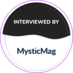 A circle, top half black with "Interviewed By" and the white bottom half reads "MysticMag"