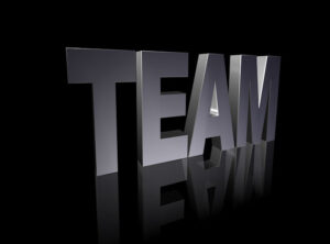 a black background with a shiny black surface which reflects the word "TEAM" in grey.